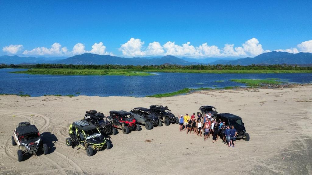 a group of people standing in front of four motorcycles on a beach at Tuya Casita in Zihuatanejo