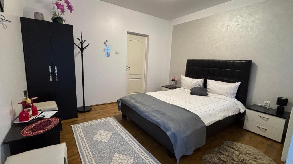 a bedroom with a large bed and a black cabinet at Pensiunea Izabel in Lacu Rosu