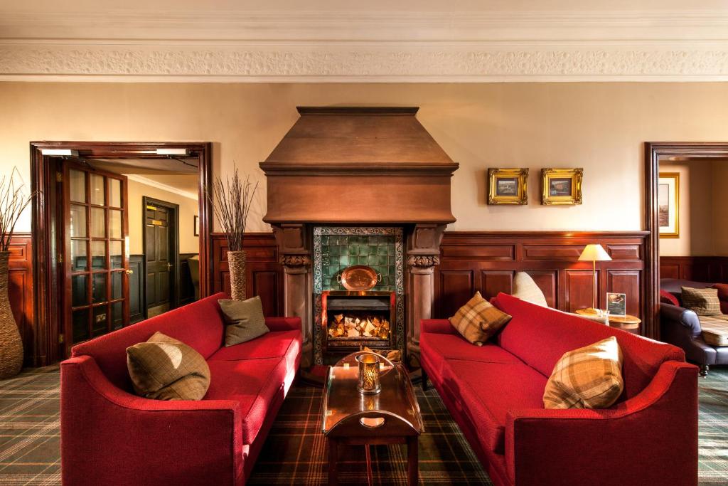 a living room with two red couches and a fireplace at Leonardo Boutique Huntingtower Perth in Perth