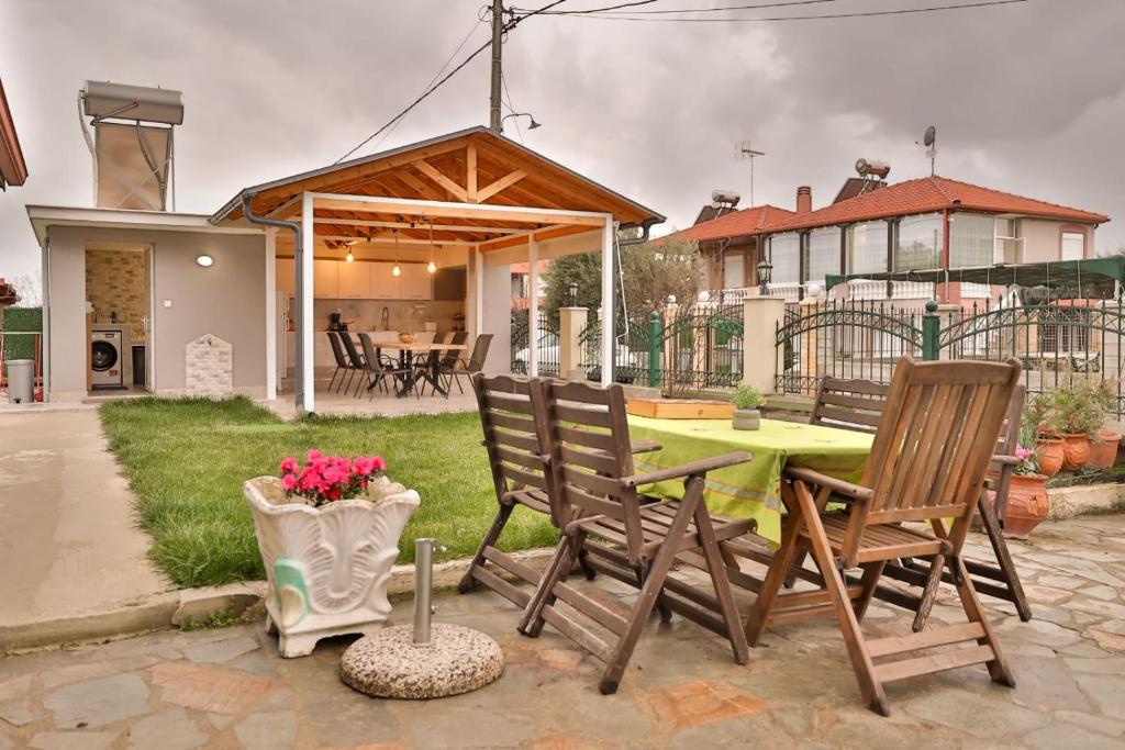 a patio with a table and chairs and a house at Villa Lydia Kariani in Karianí