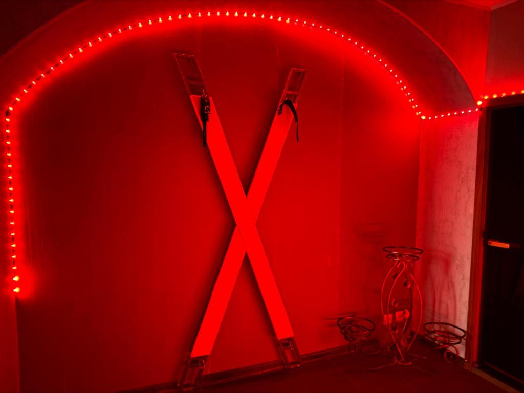 a red lighted room with a large x sign at BDSM accommodation Tallinn, Private Luxury Romance Studio Apartment Tallinn Old Town adults only in Tallinn