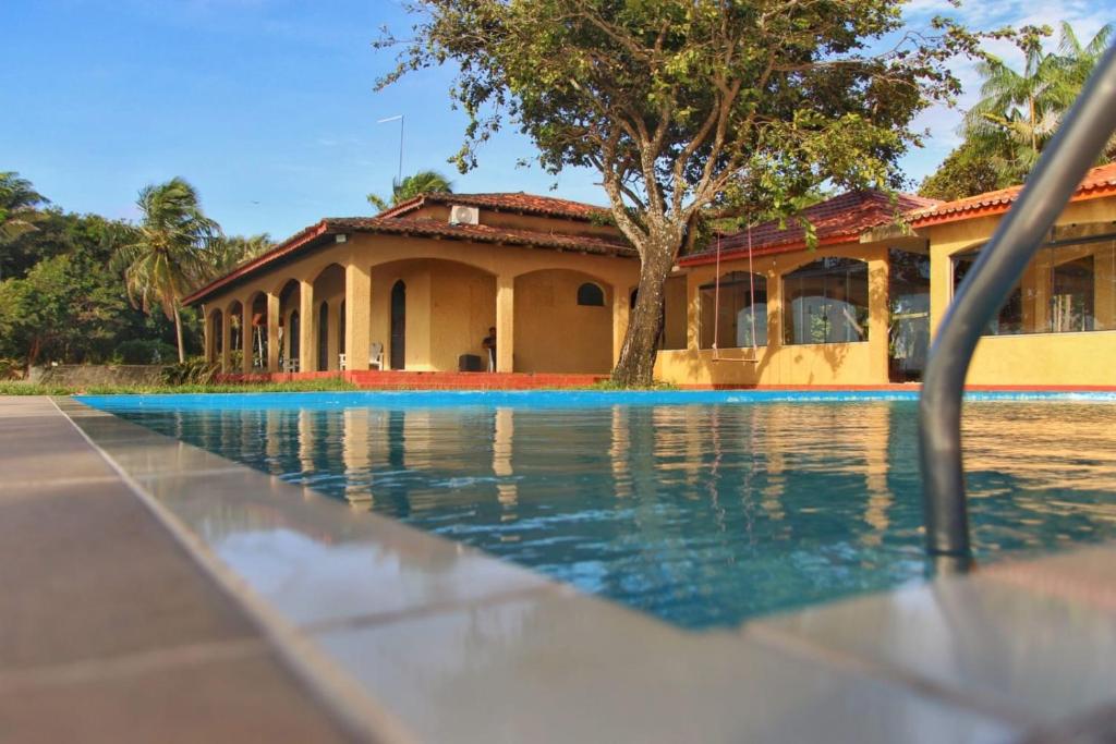 a swimming pool in front of a house at Pousada Marajo in Salvaterra