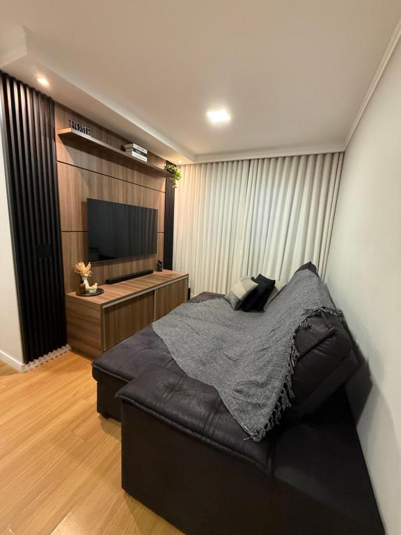 a bedroom with a bed and a flat screen tv at Carvalho Home in Londrina