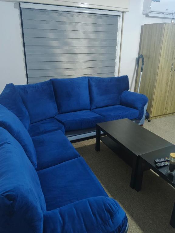a blue couch in a living room with a coffee table at Kamaliyeh studio in Amman