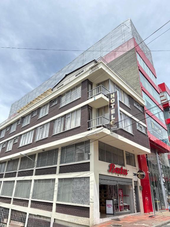 a large building on a city street with a store at Hotel Dinastia in Ipiales