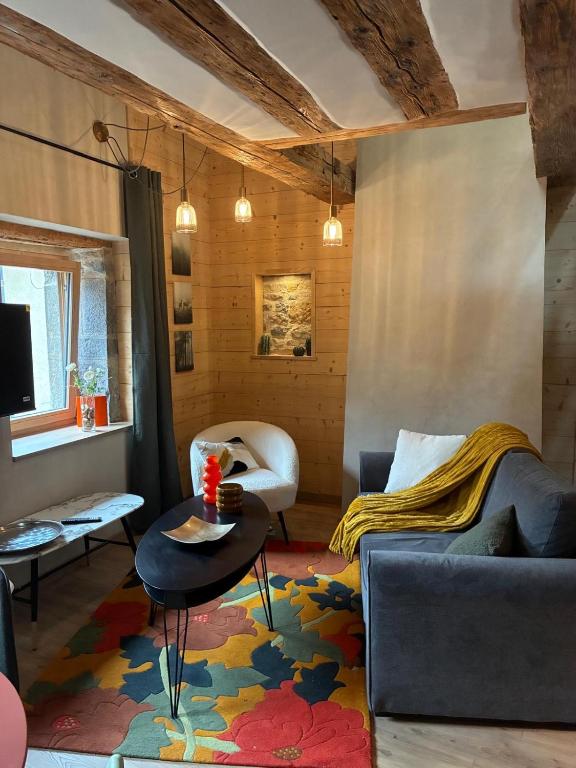 a living room with a couch and a table at Loft Cocooning et Lumineux in Arbois