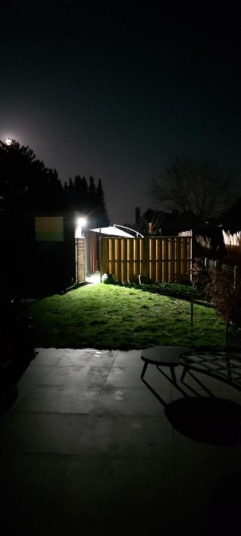 a backyard at night with a fence and a building at Le tiny de Laly - climatisation -wifi - jardin - airport navette in Pont-de-Loup