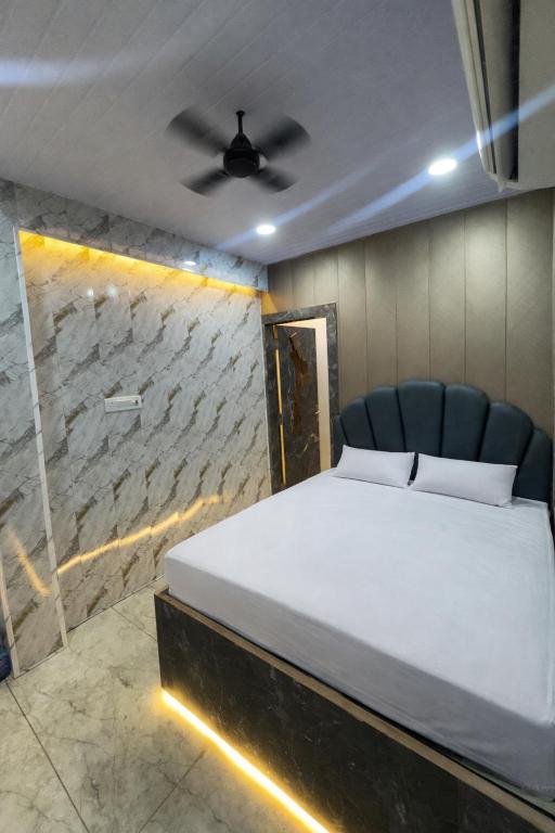 a bedroom with a bed and a ceiling fan at Lari Guest House in Gorakhpur