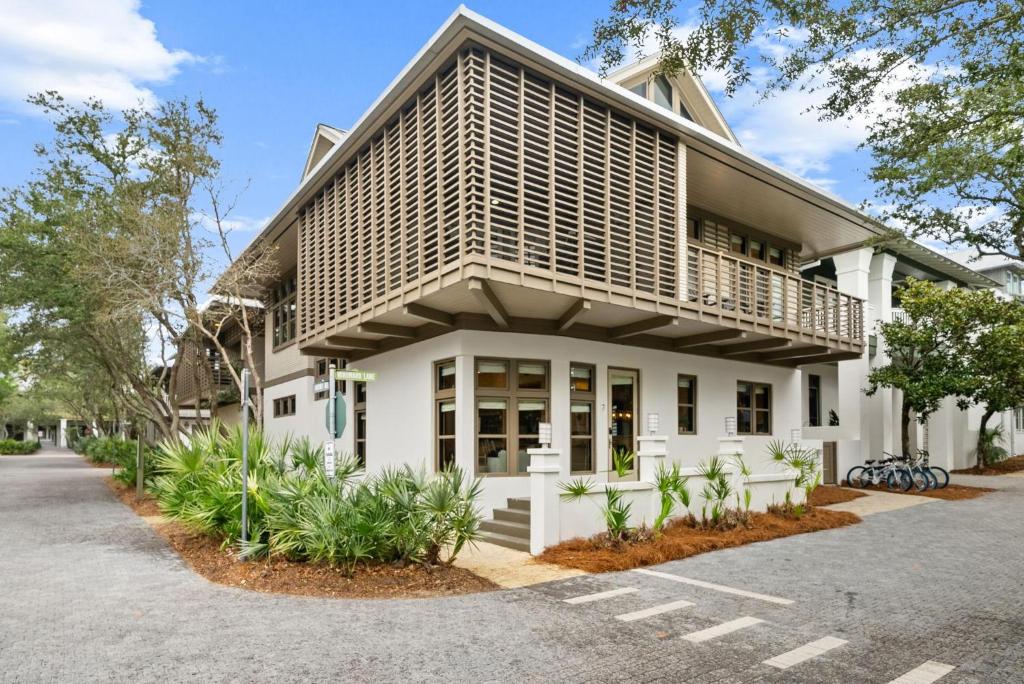 a white building with a balcony on top of it at Brighton Cottage in Rosemary Beach