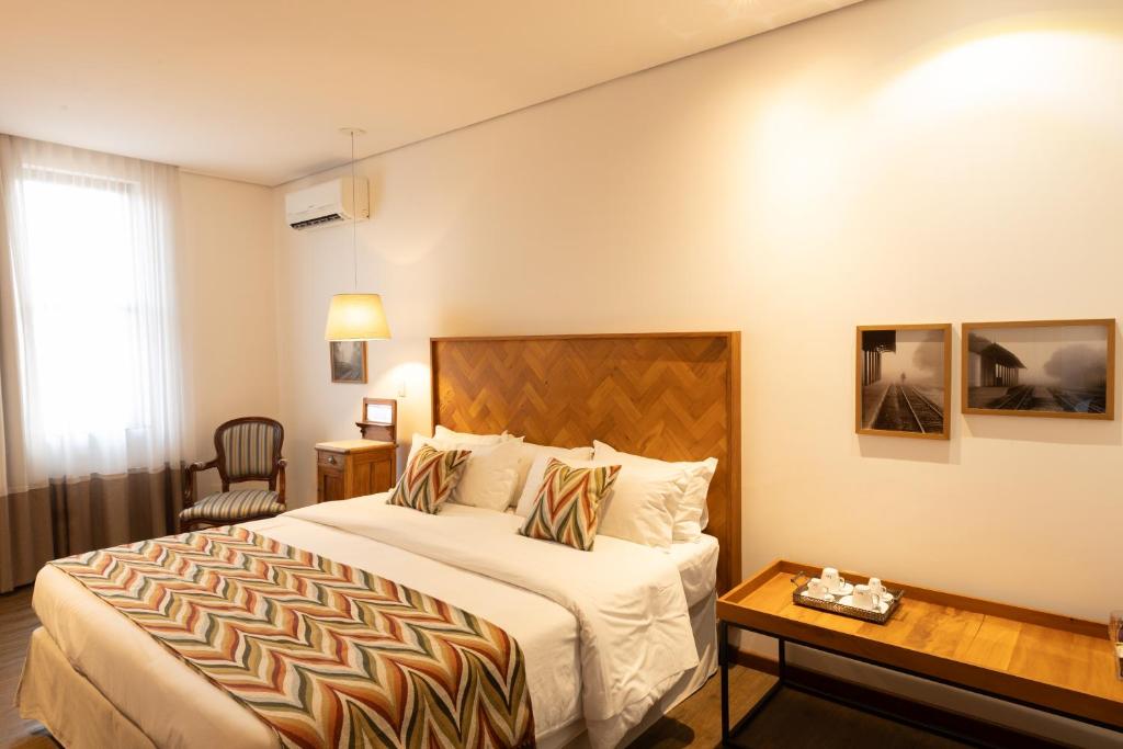 a hotel room with a bed and a table at Pousada Armazém 26 in Tiradentes