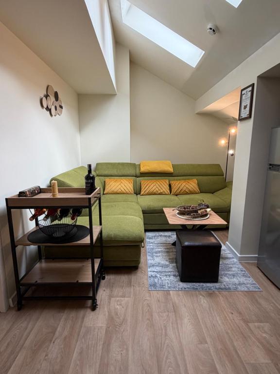 a living room with a green couch and a table at Chamkoria Forest apartment in Borovets