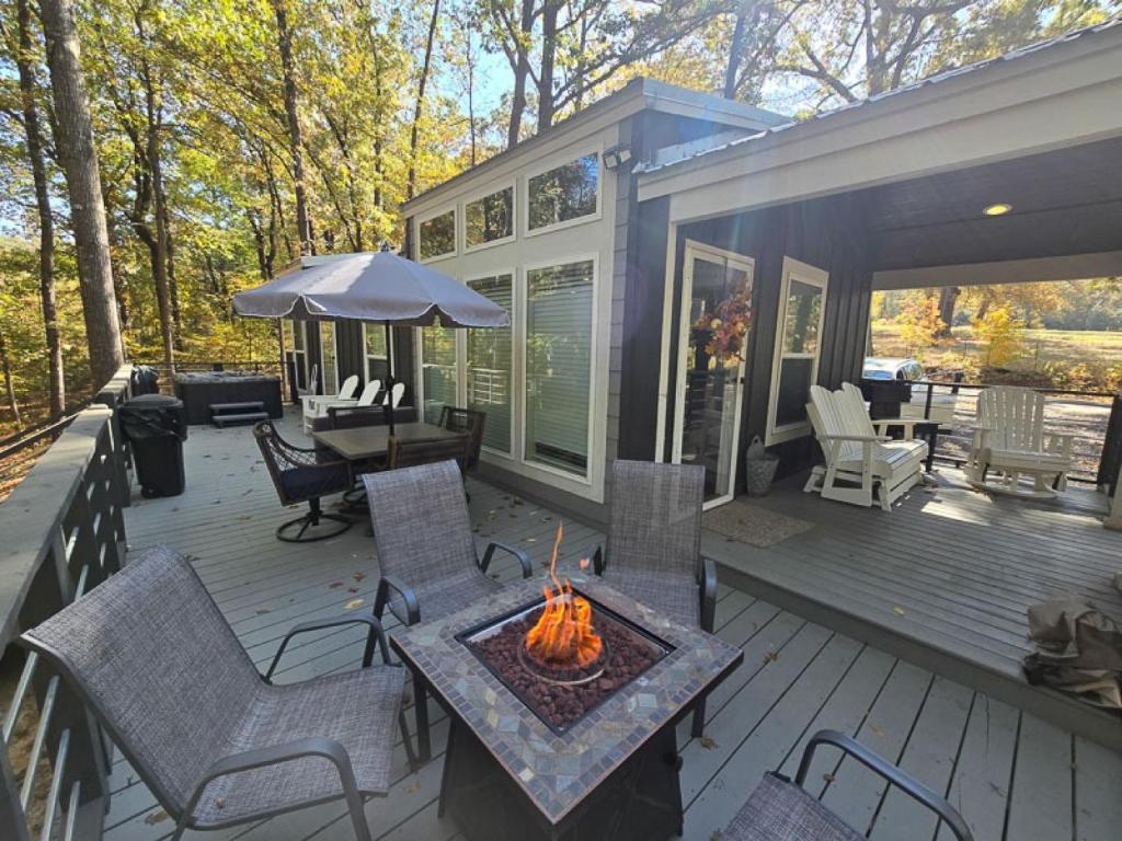 a screened in porch with a fire pit on the deck at Romantic Getaway Hot Tub Keyless Arrival in Broken Bow
