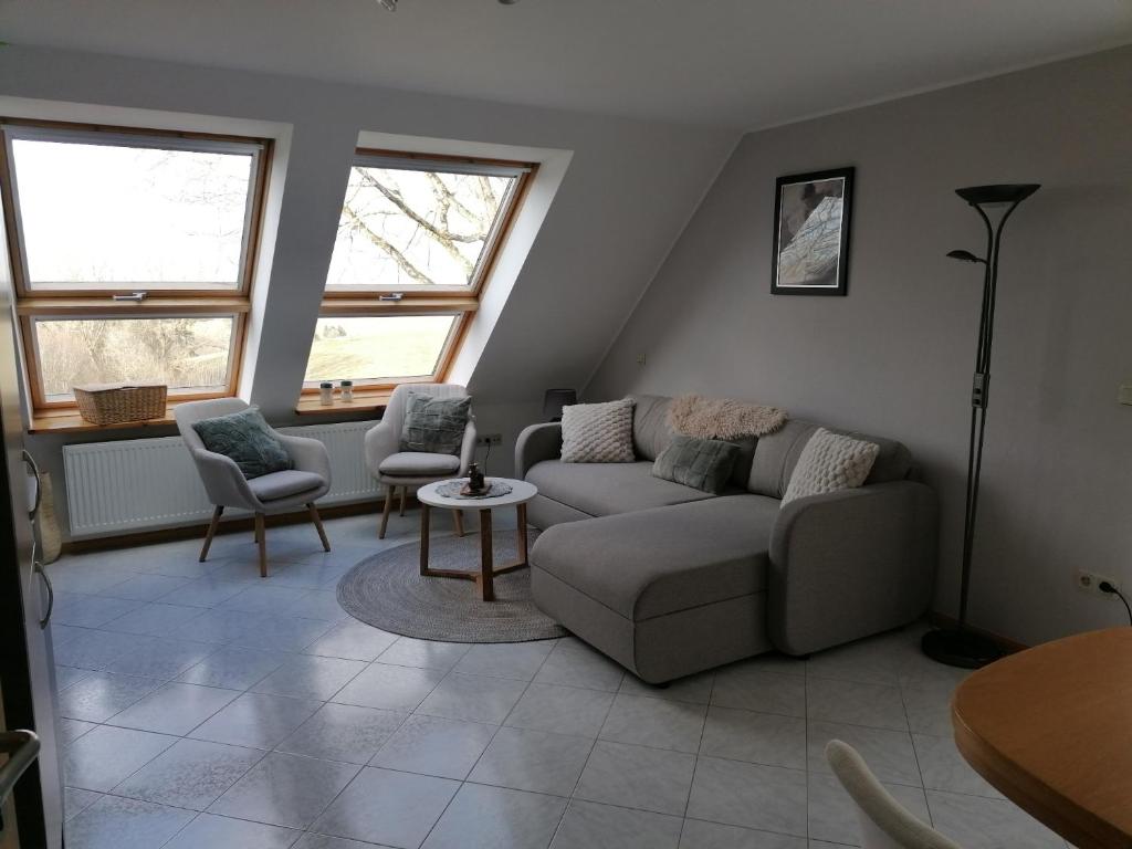 a living room with a couch and two chairs at Die kleine Feine in Olmscheid