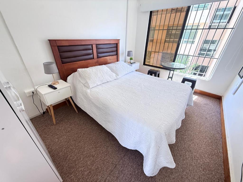 a bedroom with a large white bed and a window at Hostal EntreOrientes in Viña del Mar