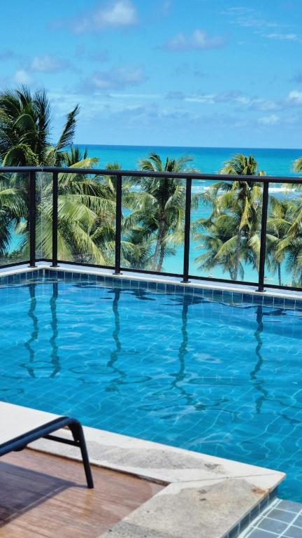 a swimming pool with a view of the ocean at Porto de Galinhas PORTO EXCLUSIVE BY AFT in Porto De Galinhas