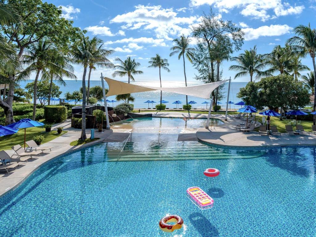 a pool at a resort with palm trees at OZO Chaweng Samui in Chaweng