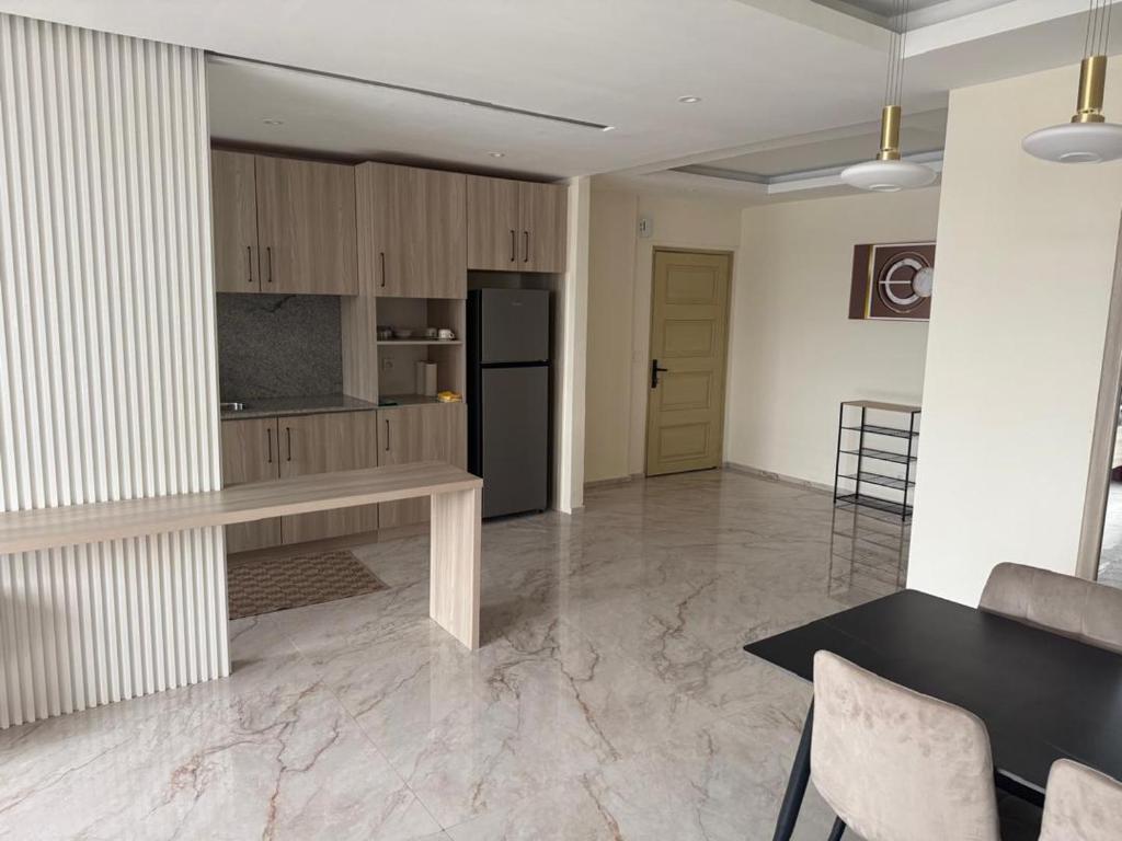 Una sala de estar con una mesa y una cocina. en Appartement Horizon 8, en Abiyán
