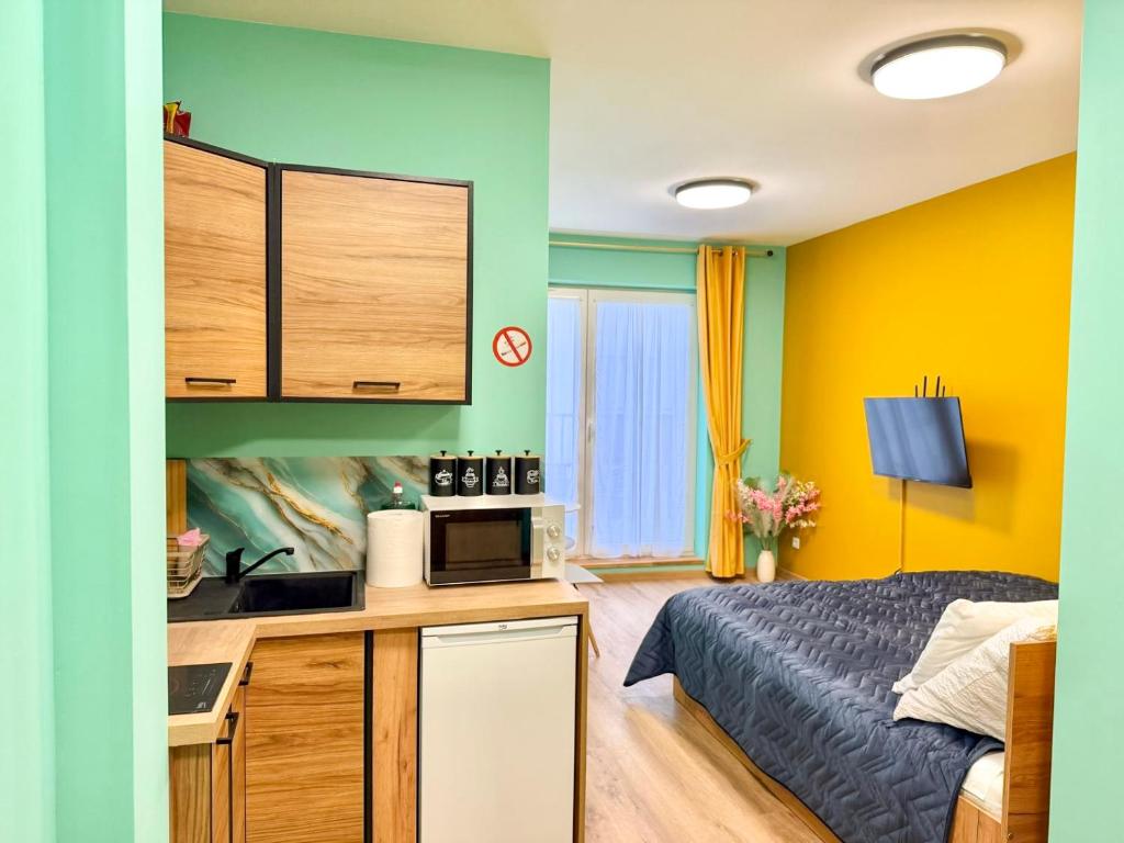 a bedroom with a bed and a kitchen with a microwave at Rumia Apartment by JumpInHere in Rumia