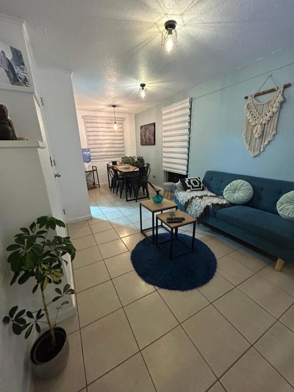 a living room with a blue couch and a table at Hotel Boutique Paqari casas completamente amobladas in Vallenar
