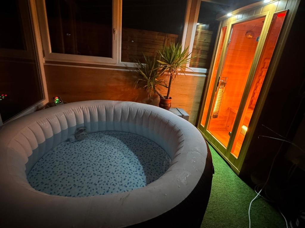 a large bath tub in the corner of a room at MaNo Apartman Siófok in Siófok