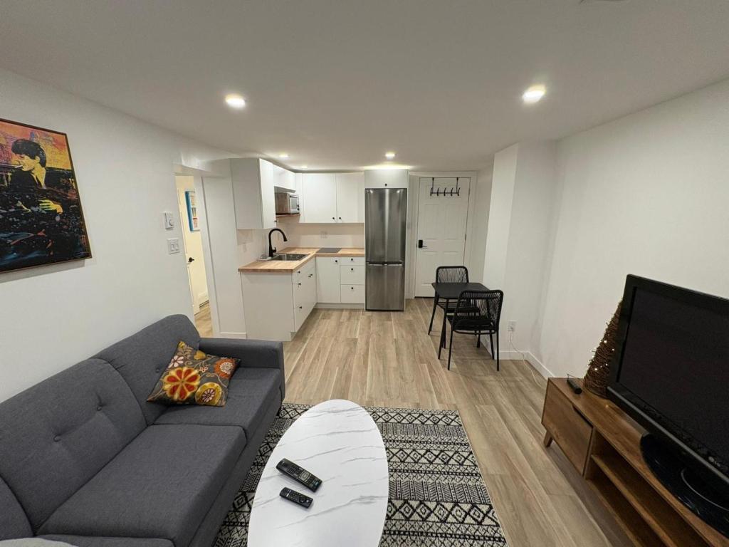 a living room with a couch and a kitchen at Private Suite Jones Lake- West Moncton in Moncton