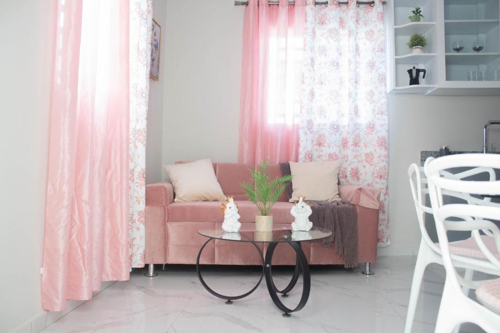 a living room with a pink couch and a table at Carrasco Apartamentos in Nagua
