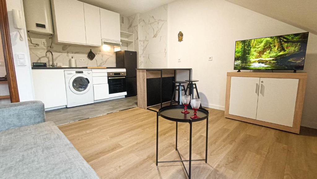 a living room with a table and a kitchen at Atico moderno en Langreo in Langreo