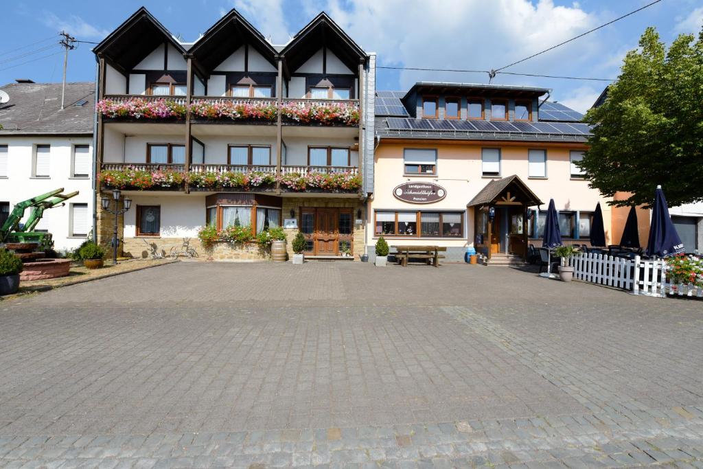a large building with a courtyard in front of it at Landgasthaus Pension Schmidthöfer in Berschweiler