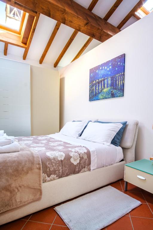 a bedroom with a large bed and a painting on the wall at La Dolce Imola-Bilocale in centro storico in Imola