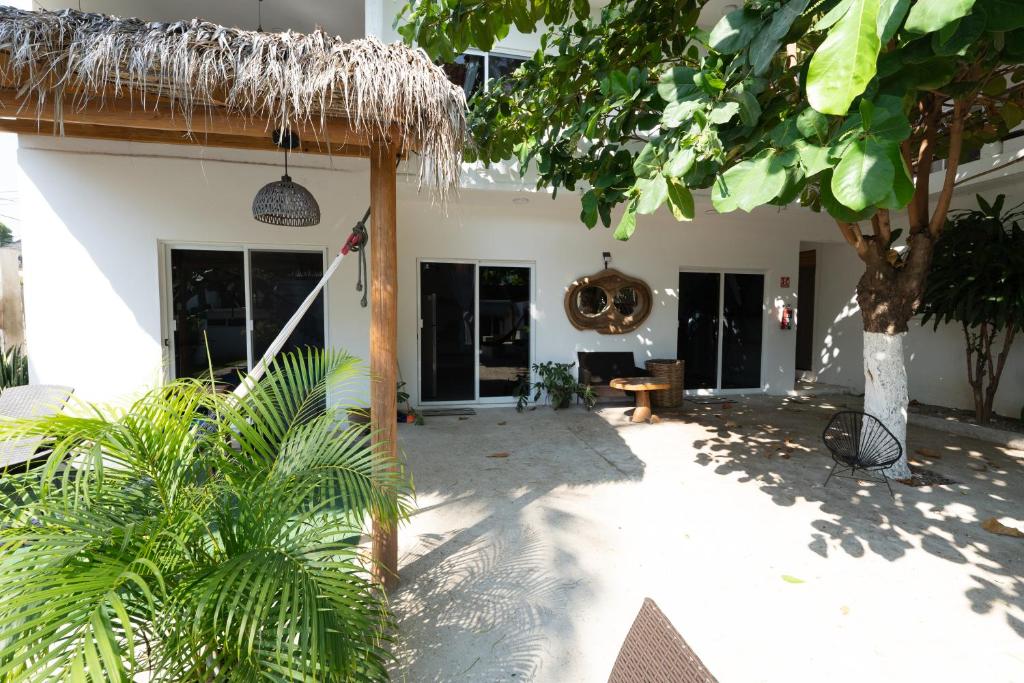 a patio of a house with a straw roof at Suku'un in Brisas de Zicatela