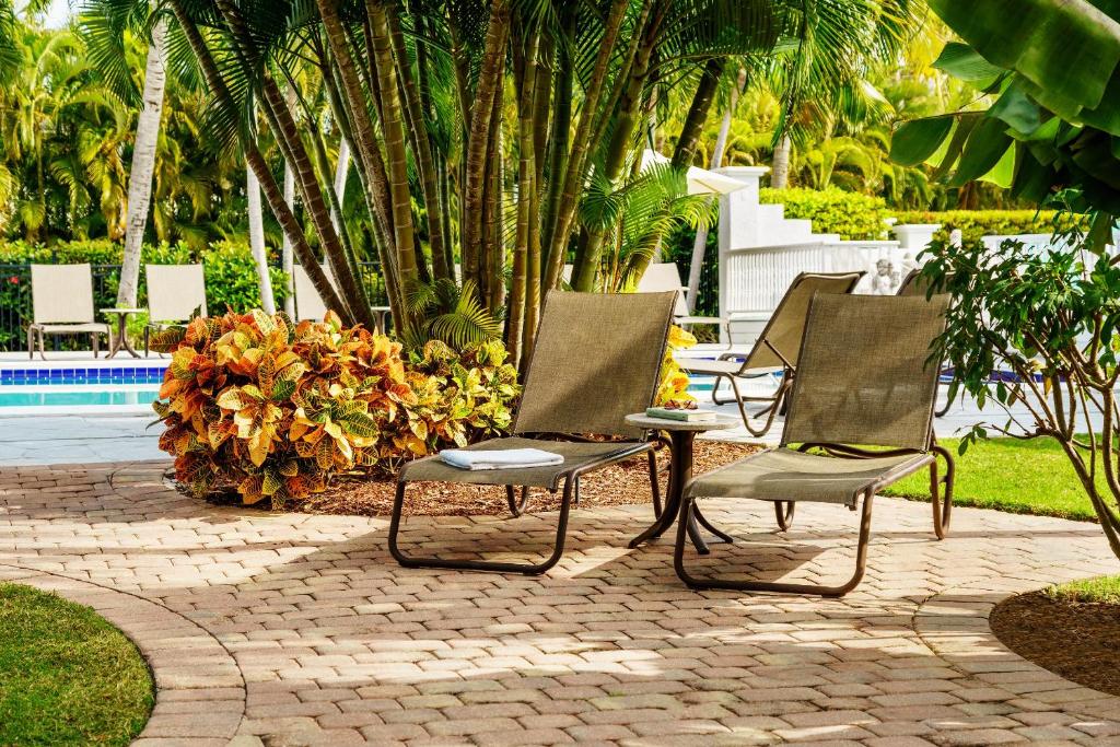 two chairs sitting on a patio near a pool at Olde Marco Island Inn and Suites in Marco Island