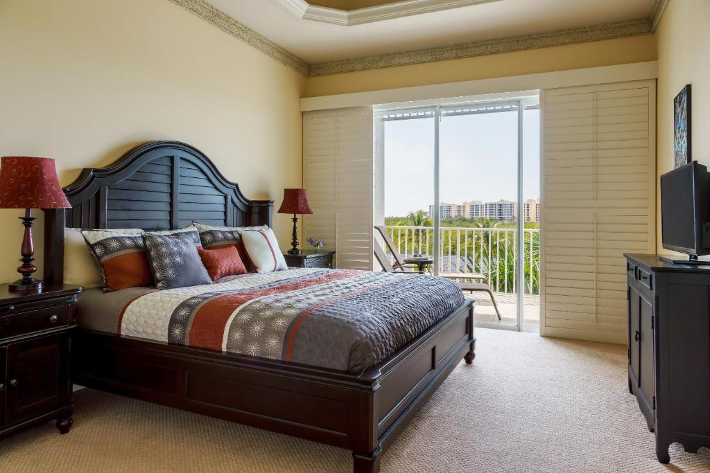 a bedroom with a large bed and a balcony at Olde Marco Island Inn and Suites in Marco Island