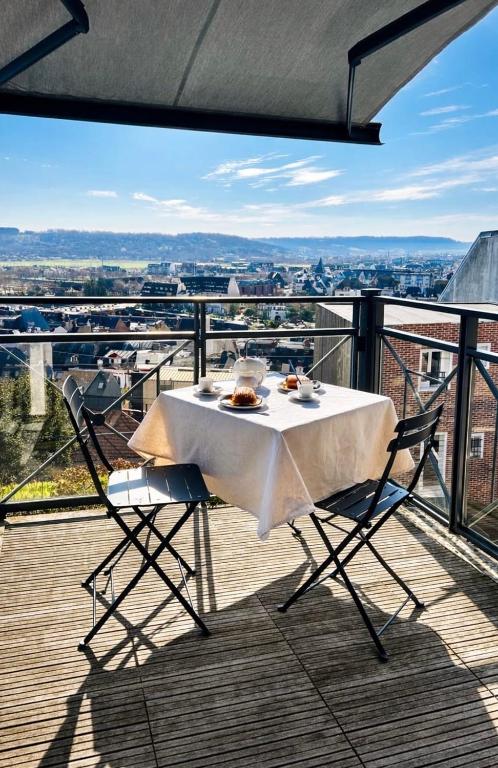 a table and chairs on a balcony with a view at Le Clos Savignac in Trouville-sur-Mer