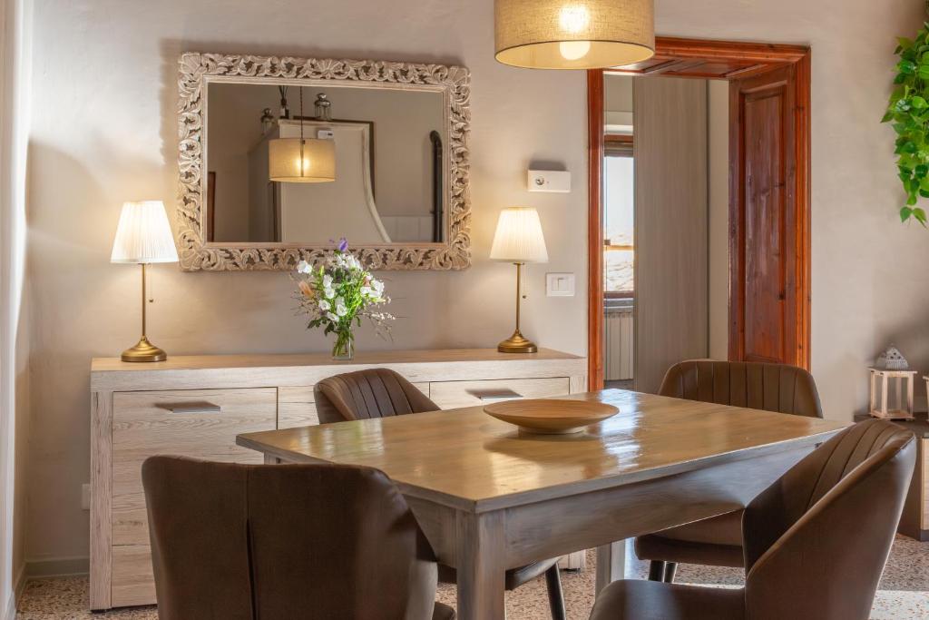 a dining room with a table and chairs and a mirror at Dimora San Lazzaro Tuscany in Cetona