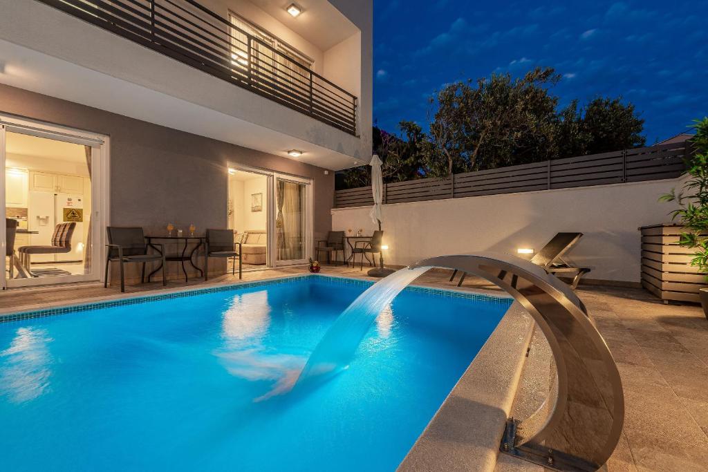 a swimming pool in the backyard of a house at Villa Ursula in Pakoštane