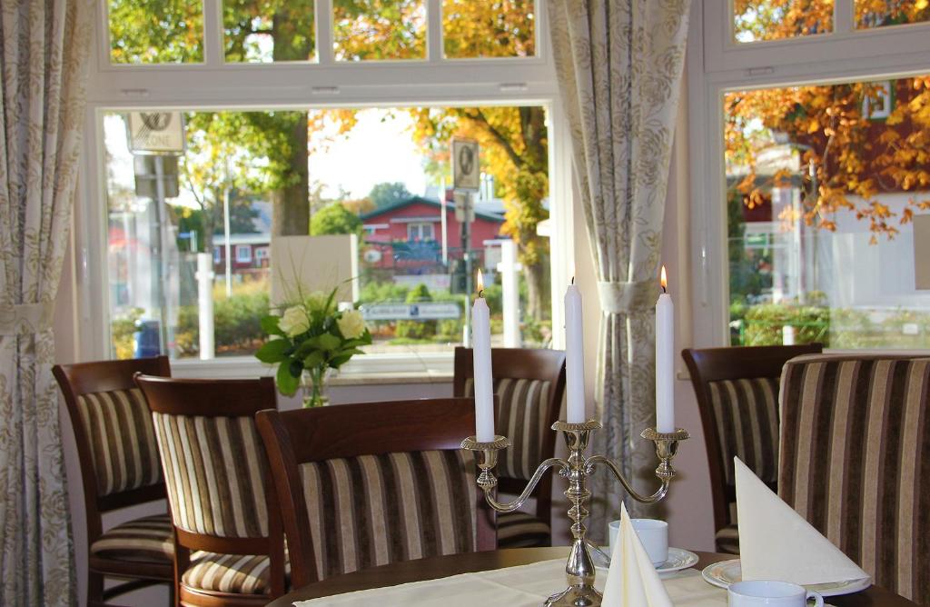 a table with a candle on a table with a window at Hotel & Café Strandeck in Prerow