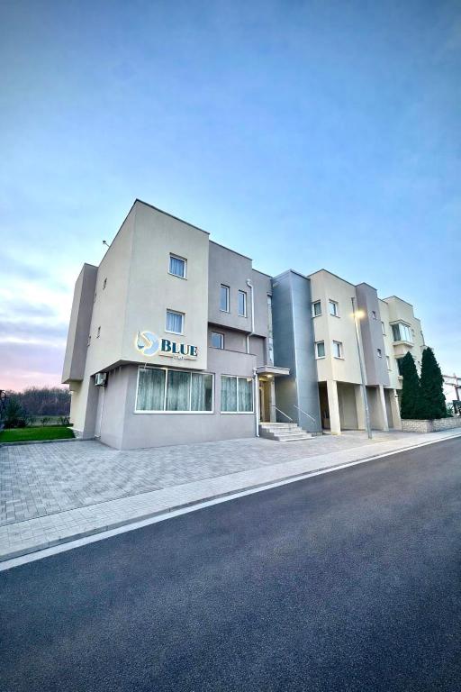 a building with a blue sign on the side of a street at Hotel BlueTwo Međugorje in Međugorje