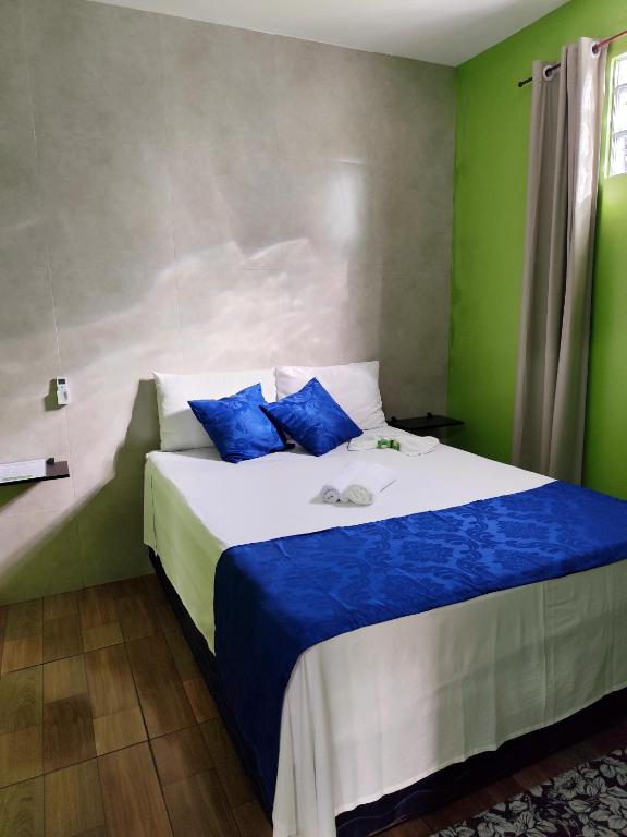a bedroom with a large bed with blue pillows at Casa Quartzo in Lençóis