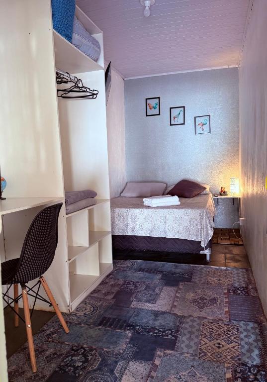 a small bedroom with a bed and a desk at Quarto 1 econômico Centro Itajaí in Itajaí