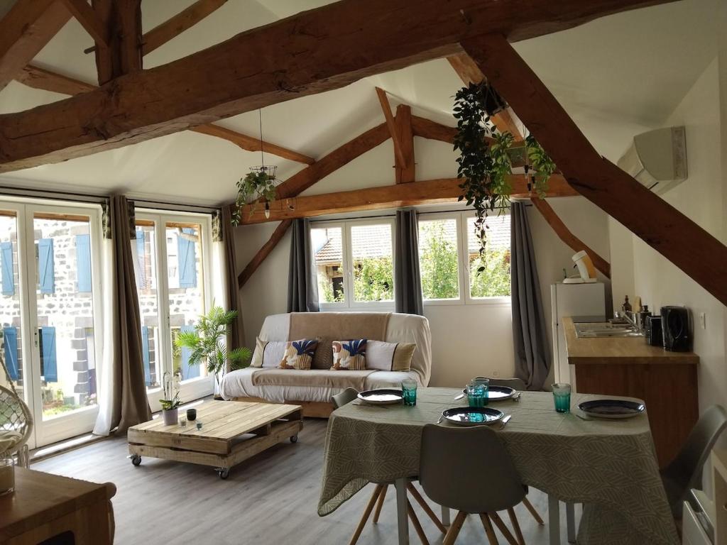 a living room with a table and a couch at La Cabane aux Hirondelles in Entraigues