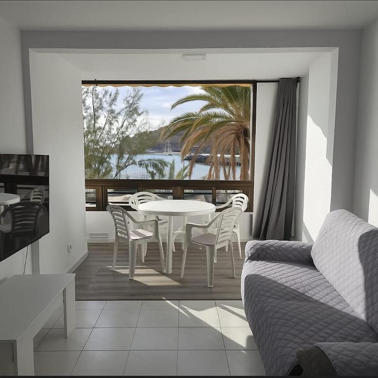 a living room with a table and chairs on a balcony at Beachfront Patalavaca in Patalavaca