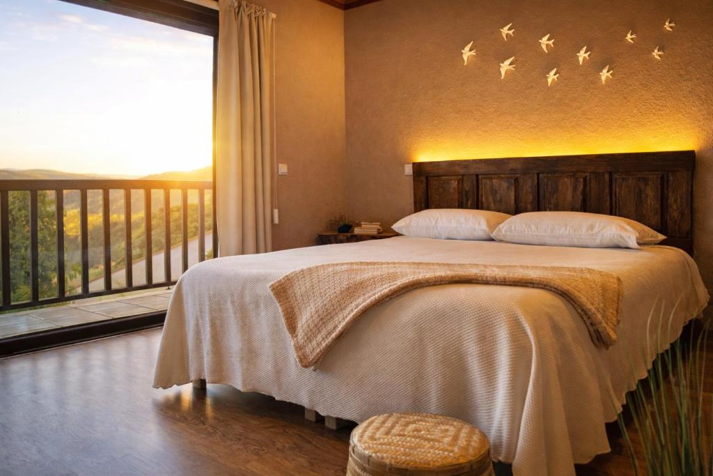 a bedroom with a bed with birds on the wall at Sweet Quintanilha in Quintanilha
