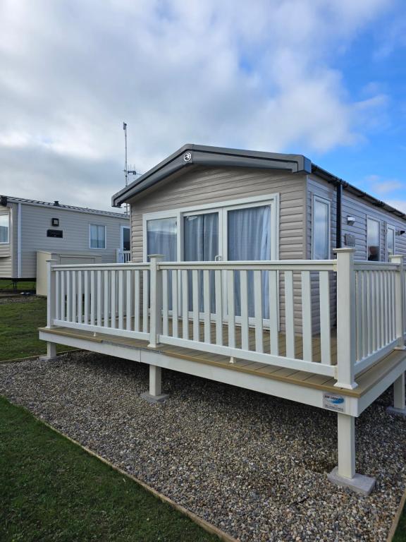 a mobile home with a white railing and a porch at Pine Ridge B6 in Reighton