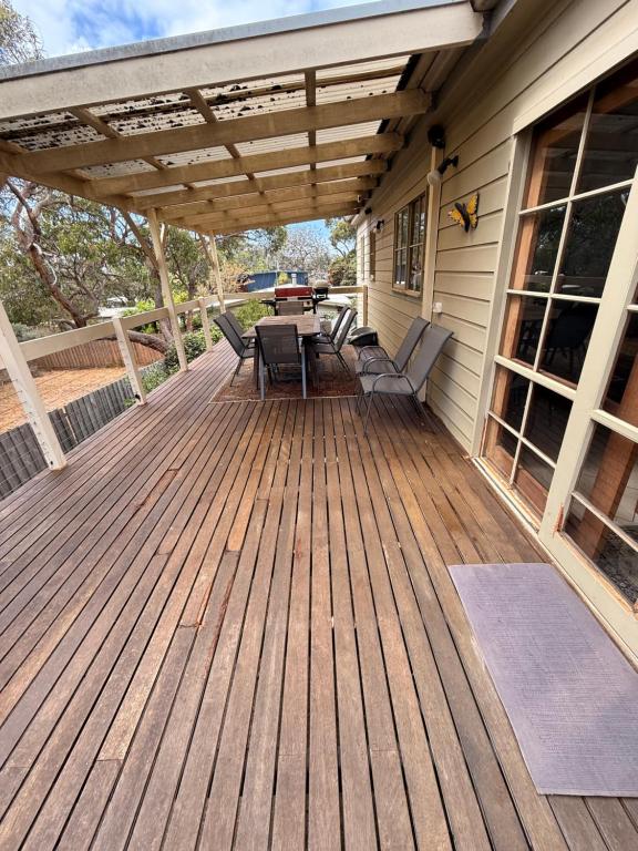 a wooden deck with a table and chairs on it at David's at Hillcrest in Anglesea