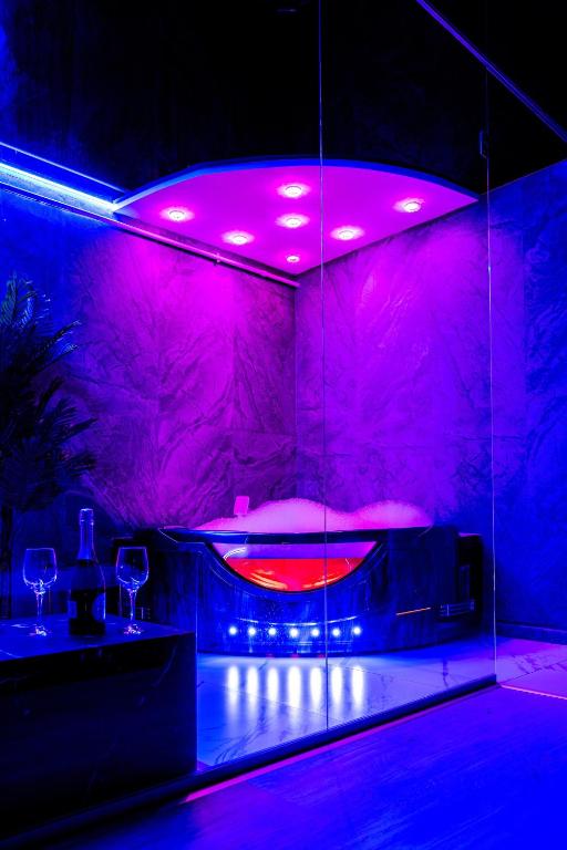 a room with a hot tub with purple lights at SECRET JACUZZl & LOVE in Bucharest