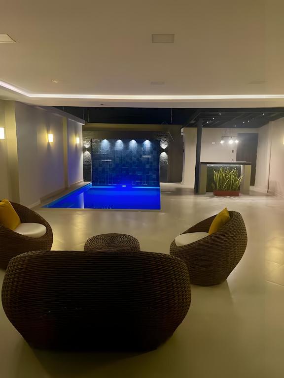 a living room with couches and a blue pool at Casa completa con piscina privada en Manta, Ecuador in Manta