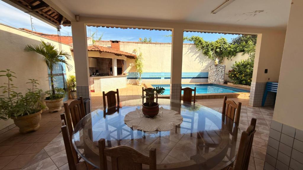 a dining room with a table and a swimming pool at Sobrado de lazer rita in Aparecida de Goiânia