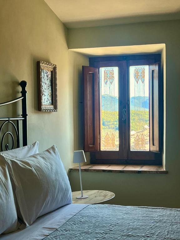 a bedroom with a bed and a window at La Gemma del Subasio nel Castello di Collepino - Spello in Collepino