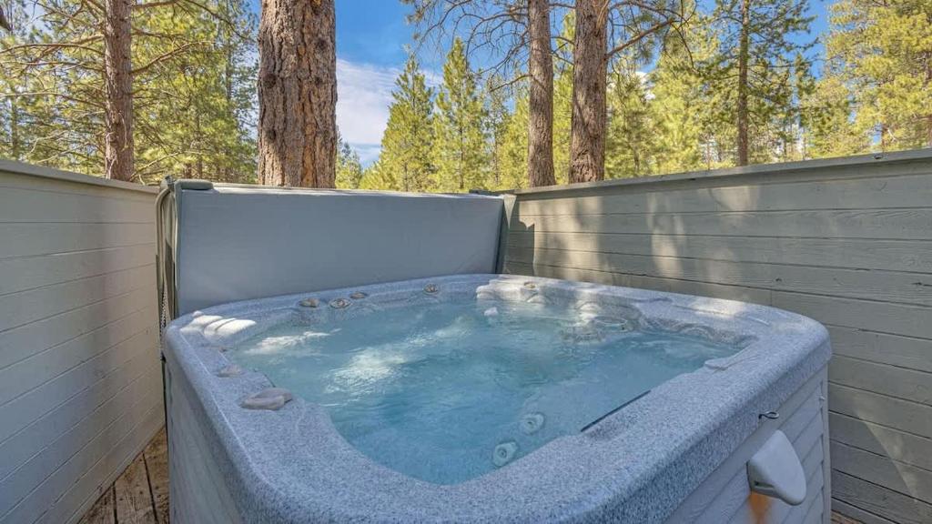 a jacuzzi tub in a backyard with trees at Pine Mountain - Unit 13 in Sunriver
