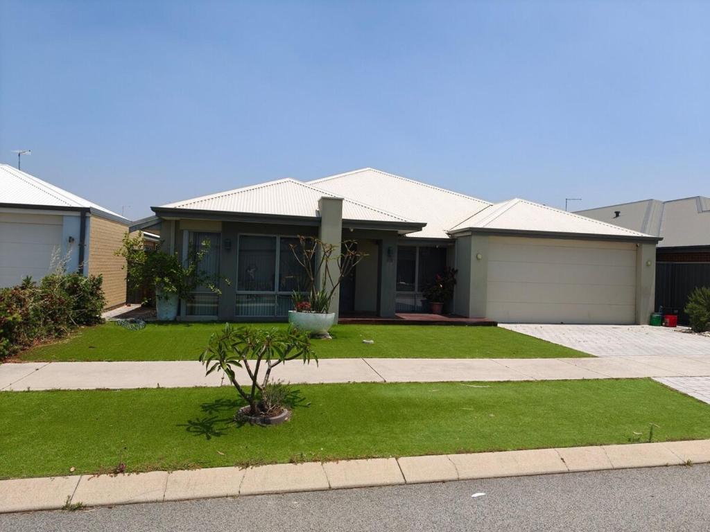 a house with a small tree in the front yard at Piara Sojourn in Perth